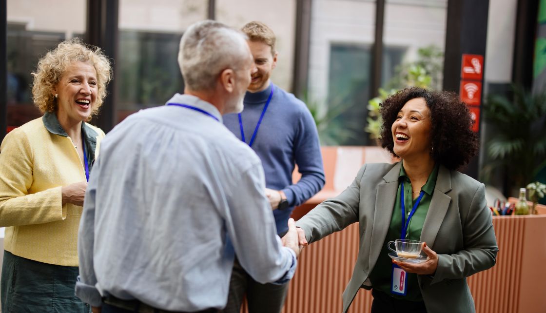 Multiple people shaking hands at a business meeting