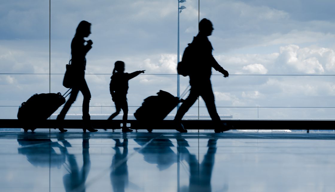 Family pulling suitcases in an airport
