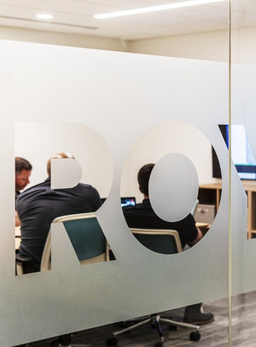 Three coworkers using multiple computers at night