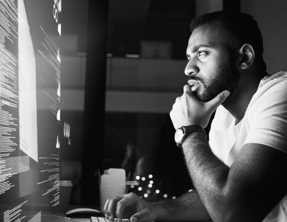 Man looking at computer with a contemplating look on his face